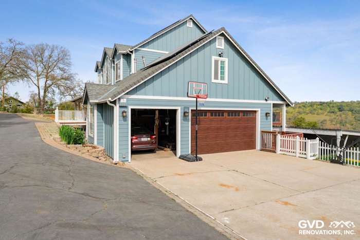 Updated home exterior featuring new blue James Hardie siding and a modern garage door in Shingle Springs