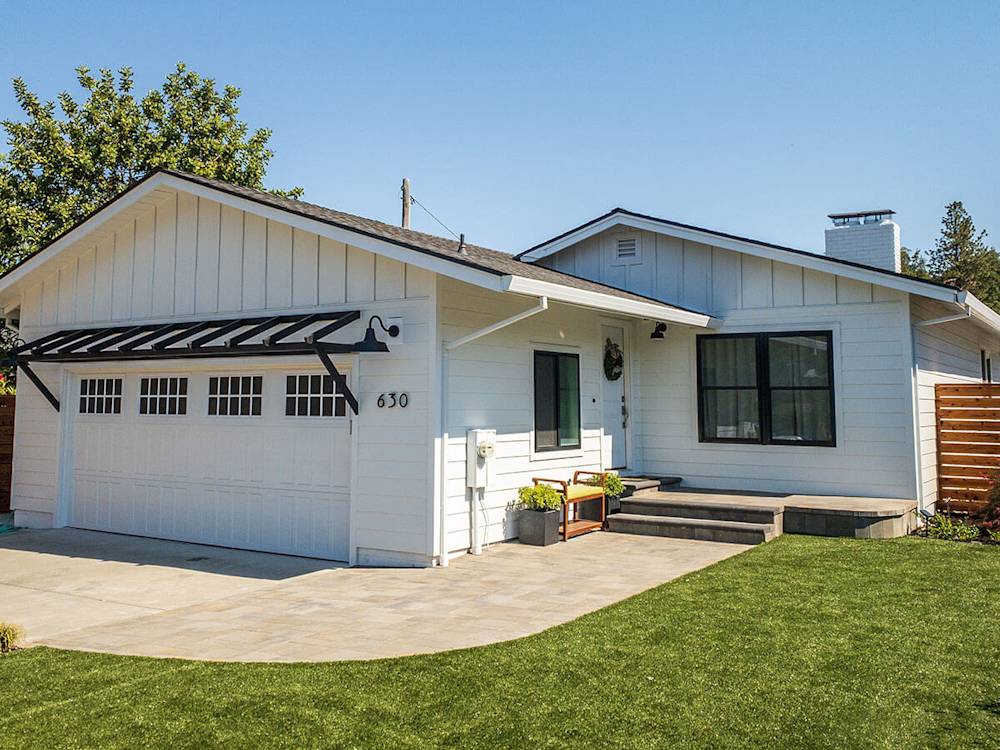 Modern white siding with black accents, new landscaping, and contemporary design elements