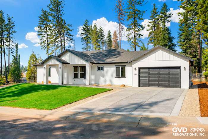 Modern single-story home exterior with white board and batten siding, gray accents, and manicured lawn in Paradise, CA