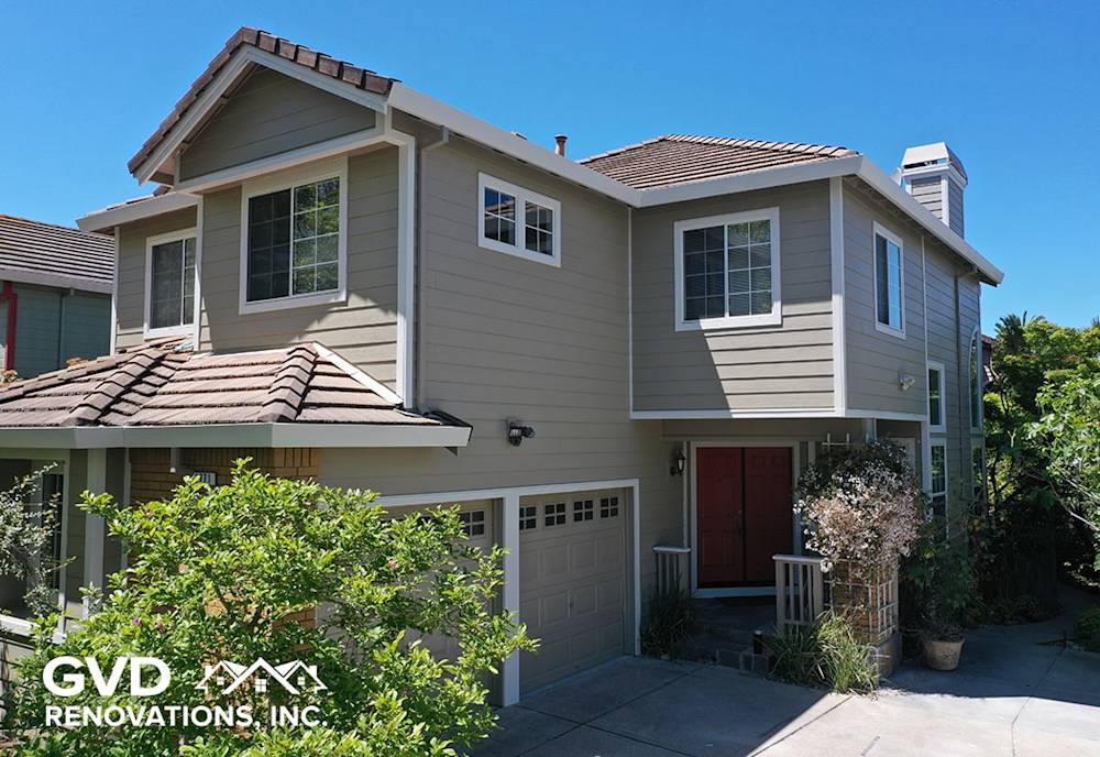 Updated beige siding with modern features and vibrant red entry door