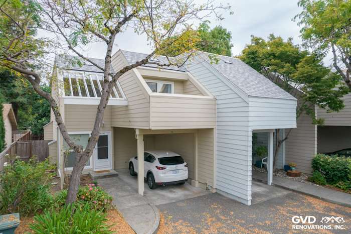 Modern quadplex with newly installed James Hardie siding in light beige, featuring a carport and landscaped area