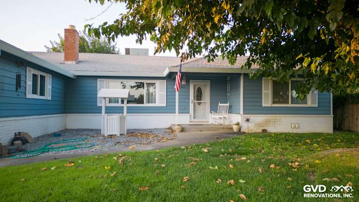 Home exterior featuring new Alside Prodigy vinyl siding in blue, with white brick trim and a welcoming front porch