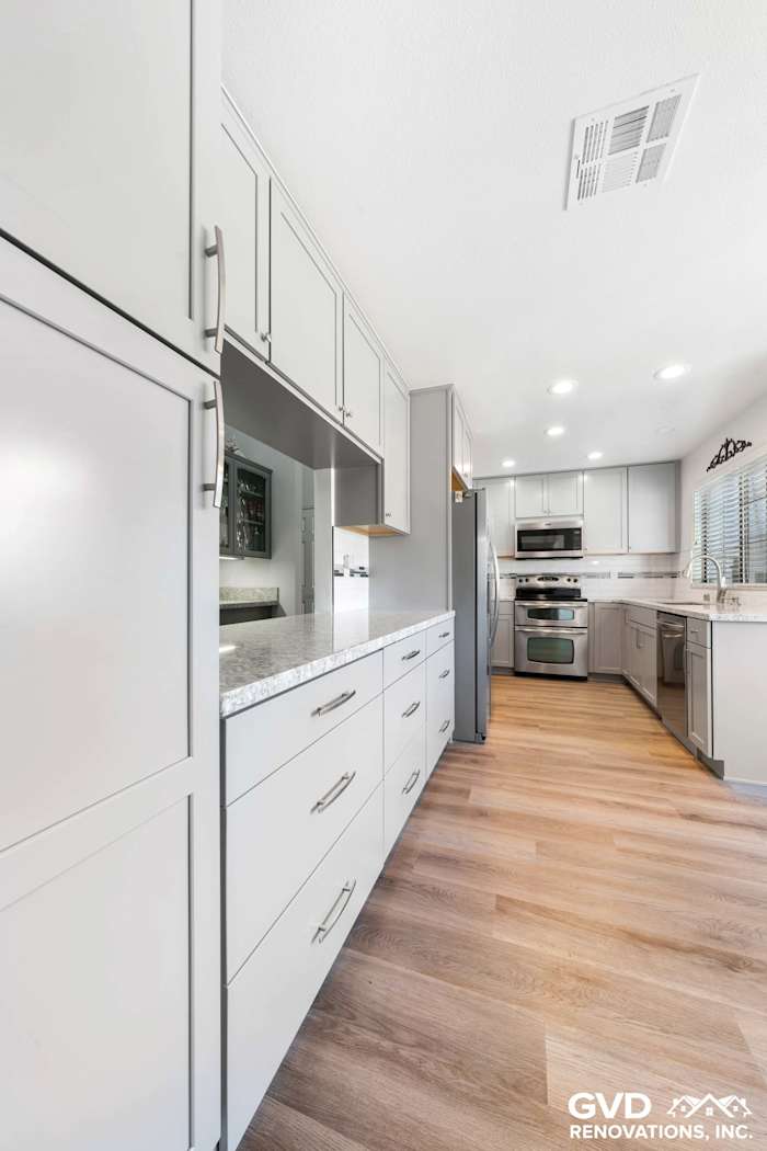 Modern kitchen remodel in Carmichael featuring sleek gray cabinetry, quartz countertops, and stainless steel appliances