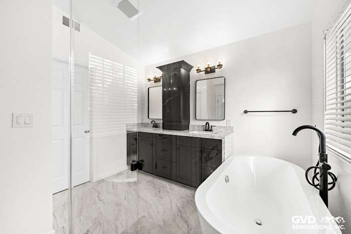 Modern bathroom remodel in Sacramento featuring double sink vanity, elegant freestanding tub, and stylish mirrors