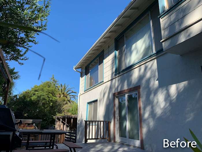 Exterior view of home in Oakland with before installation of James Hardie siding and vinyl windows, featuring a clear blue