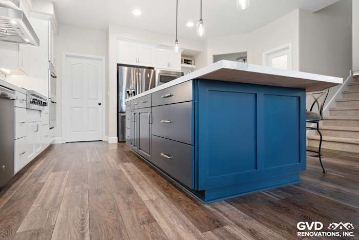 Modern kitchen remodel featuring a navy blue island with white countertop and hardwood flooring in El Dorado Hills