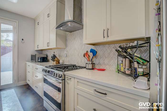 Modern kitchen remodel featuring white cabinetry, stainless steel appliances, and herringbone backsplash in Roseville, CA