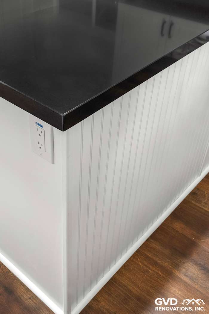 White shaker kitchen island featuring a black countertop and beadboard paneling in Loomis, CA