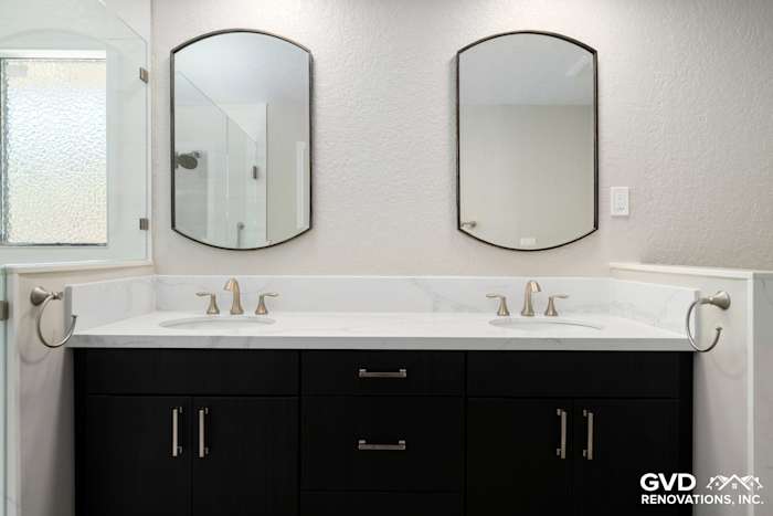 Modern master bathroom with dual sinks, dark cabinetry, marble countertop, and framed mirrors in Rocklin, CA
