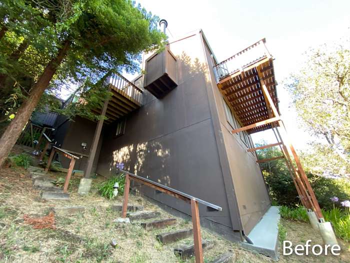 Before photo showing a home in Mill Valley with dark wood siding and a steep hillside