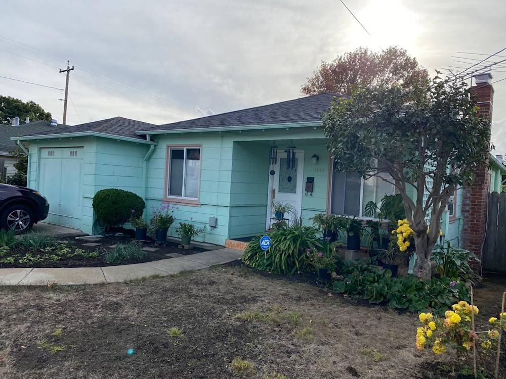 Light teal house exterior with flower beds and shrubs in Sacramento, California