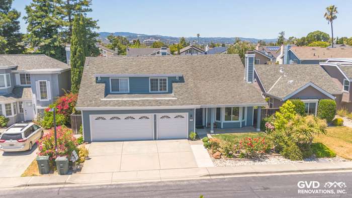 Foster City home featuring Boothbay Blue James Hardie siding, Arctic White trim, and lush landscaping