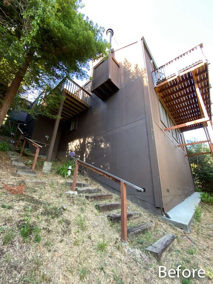 Before shot of a home exterior with brown siding, wooden balconies, and a landscaped hillside in Mill Valley