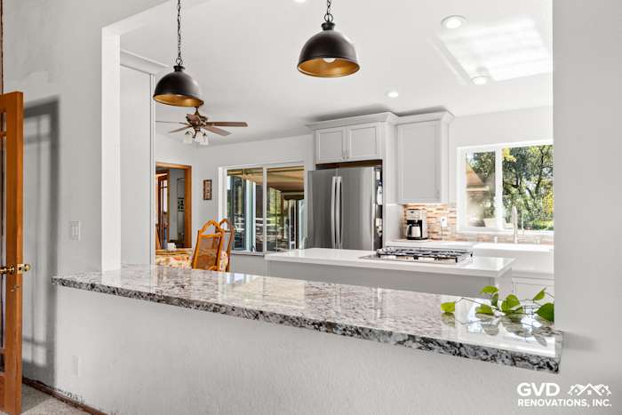Modern kitchen remodel in Greenwood with white cabinets, granite countertop, and stainless steel appliances
