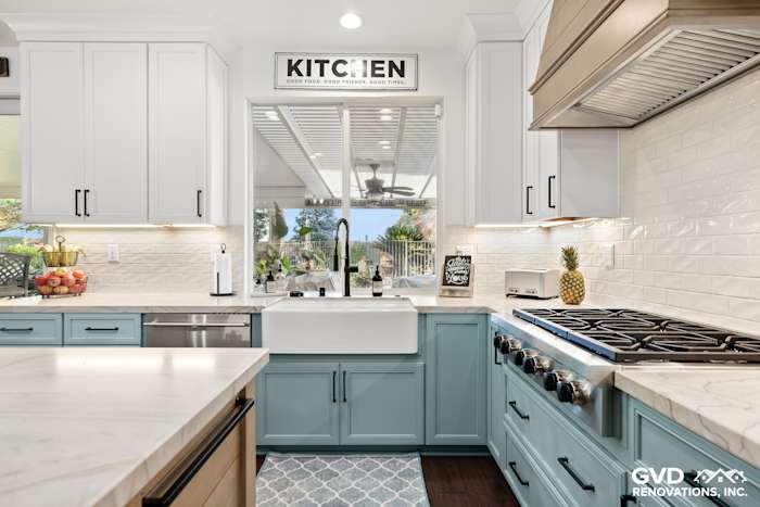 Bright kitchen featuring blue and white cabinetry, Denali White Quartzite countertops, and a farmhouse sink in Roseville
