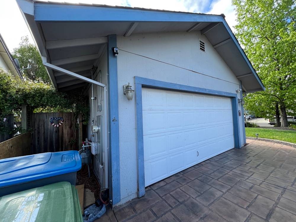 Residential garage with light blue trim and stamped concrete driveway in Laurelwood, Sacramento