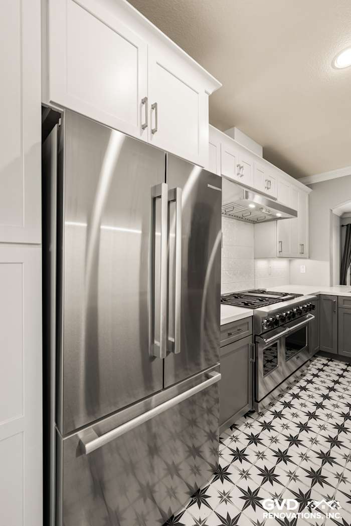 Modern kitchen in Folsom featuring stainless steel appliances, sleek cabinetry, and patterned black-and-white tile flooring