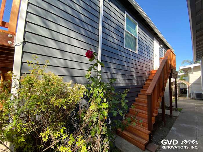 Newly installed CraneBoard vinyl siding and wooden steps leading to the home in Rio Vista