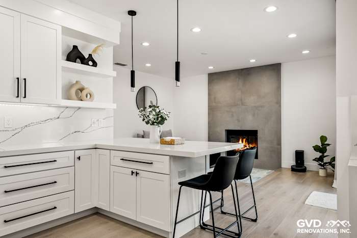 Modern kitchen with white cabinets, quartz countertops, and a sleek fireplace in Antelope, CA