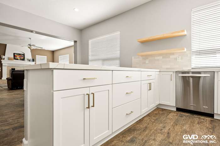 Modern kitchen in Roseville with white Diamond cabinetry, floating shelves, MSI quartz countertops, and sleek stainless