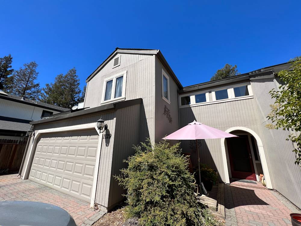 Gray siding and brick pathway leading to the entrance of a home in Northern California