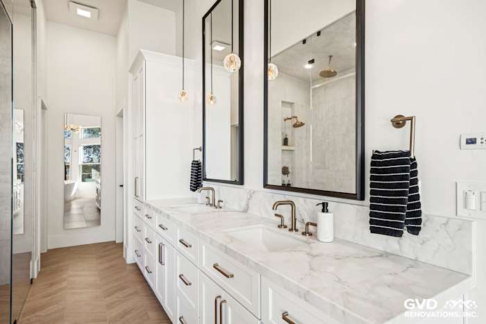 Master bathroom with dual sinks, marble countertop, modern mirrors, and stylish fixtures in El Dorado Hills remodel