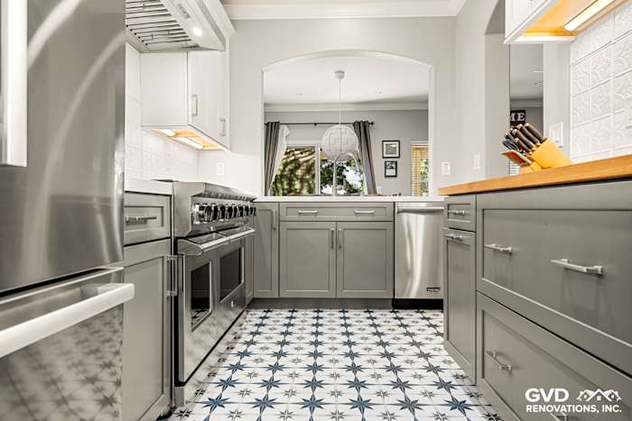 Modern kitchen remodel featuring gray cabinets, stainless steel appliances, and star-patterned tile floor in Folsom