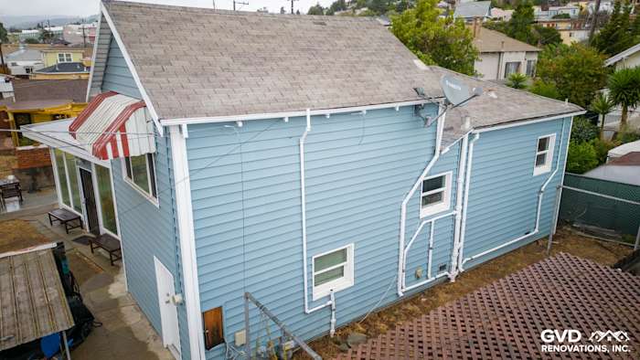 New Alside Prodigy vinyl siding in light blue, showcasing updated windows and satellite dish. Oakland home exterior