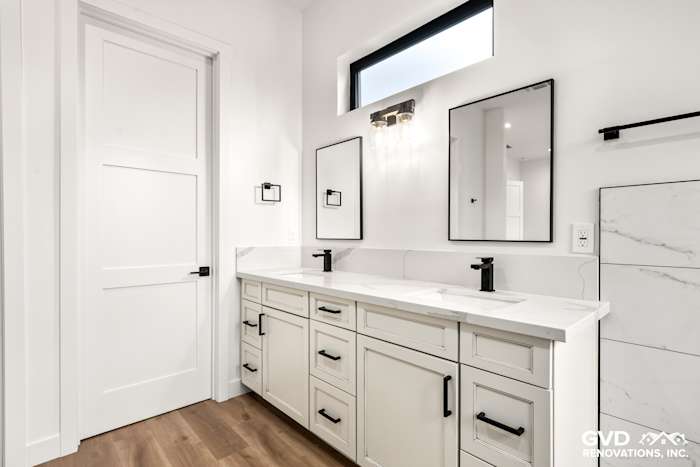 Modern bathroom in Paradise, CA featuring white cabinetry, dual sinks, and stylish black fixtures
