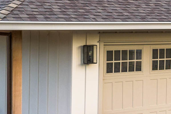 Home exterior featuring newly installed James HardiePanel Vertical Siding in Arctic White and a paved entry