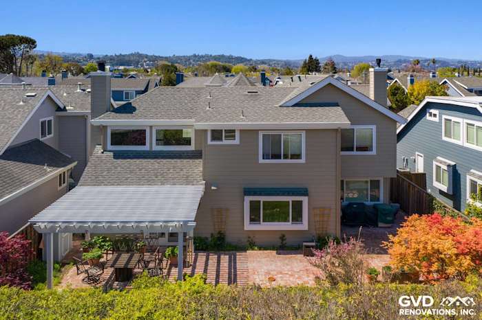 Two-story home exterior in Foster City featuring James Hardie Monterey Taupe siding and Arctic White trim with a patio