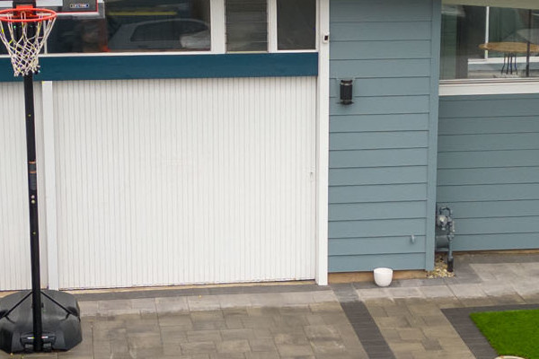 Modern home exterior in San Mateo featuring Boothbay Blue James Hardie siding and Arctic White trim, with basketball hoop