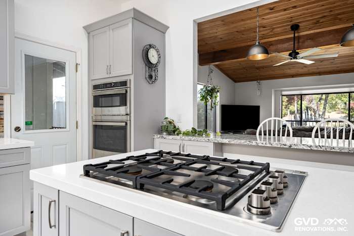 Modern kitchen remodel in Greenwood showcasing a gas cooktop, gray cabinetry, and a wooden ceiling