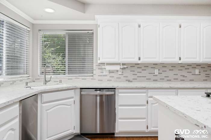 Bright kitchen featuring white cabinets, marble countertops, and a stainless steel dishwasher in Fair Oaks
