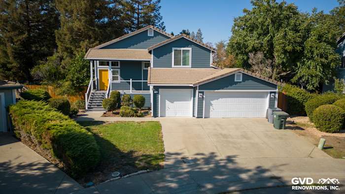 Updated home exterior in Dixon featuring blue siding, new Anlin windows, and a refreshed deck with side steps