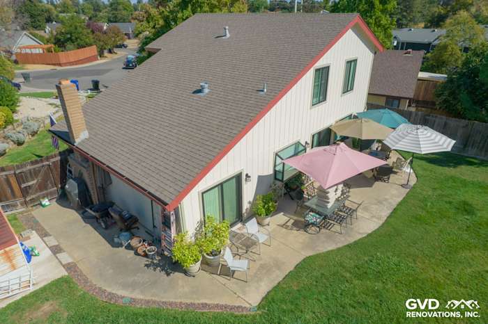 Updated home exterior showcasing T1-11 siding, Anlin windows, and a landscaped backyard patio in Orangevale