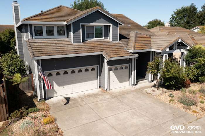 Two-story home exterior featuring James Hardie Night Grey siding, Arctic White trim, and updated garage doors in Petaluma