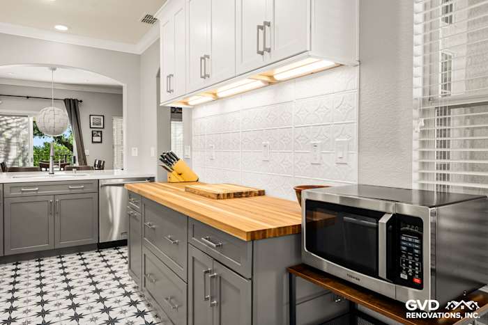 Modern Folsom kitchen with gray cabinets, butcher block countertop, patterned tile floor, and stainless appliances