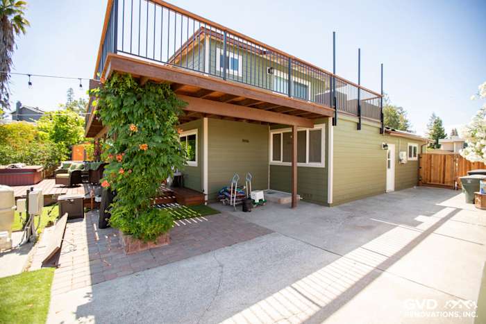Expanded outdoor area featuring new green James Hardie siding, deck, and landscaped garden in Pleasanton yard