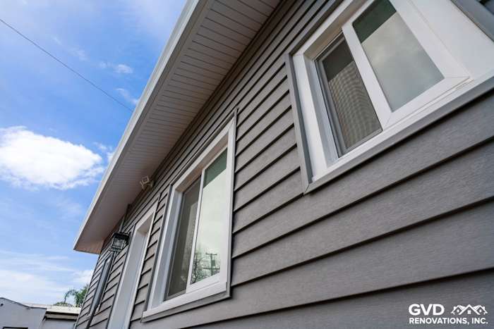 Newly installed vinyl siding in gray with white trim on a home in Dixon, showcasing a sleek, modern design
