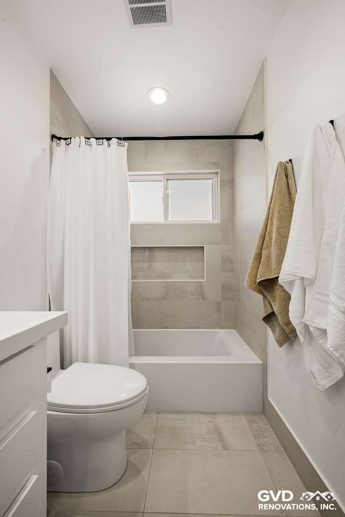 Modern bathroom featuring a freestanding tub, white walls, and neutral tile flooring in Antelope, CA