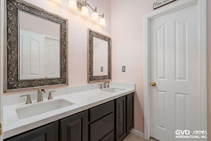 Elegant bathroom with dual sinks, dark cabinetry, and stylish framed mirrors in Sacramento remodel