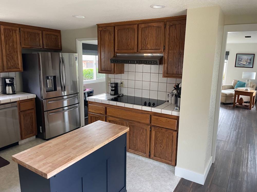 Open kitchen featuring oak cabinetry, tiled countertops, and stainless steel appliances in Fair Oaks, CA