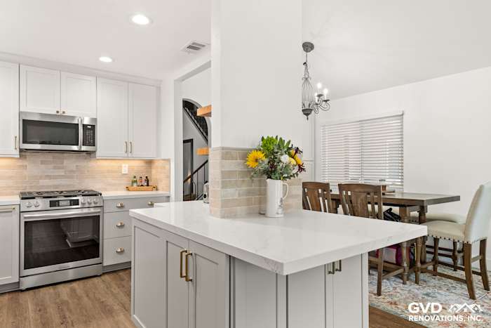 Modern kitchen remodel showcasing Waypoint cabinetry, Vadara Naurelle countertops, and MSI Brickstone Ivory backsplash