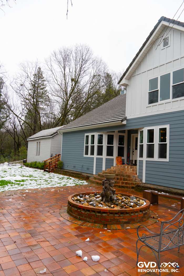 Sutter Creek home exterior featuring Boothbay Blue James Hardie siding and Milgard windows with brick patio and fountain