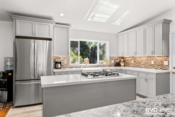 Modern kitchen remodel in Greenwood featuring gray cabinetry, quartz countertops, and tile backsplash