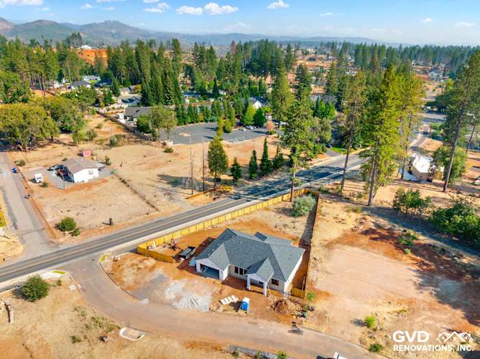 Aerial view of a new construction home with a stylish roof, surrounded by trees in Paradise, CA