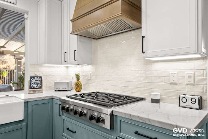 Modern kitchen with fieldstone cabinetry, Denali White Quartzite countertops, and a stainless steel range hood