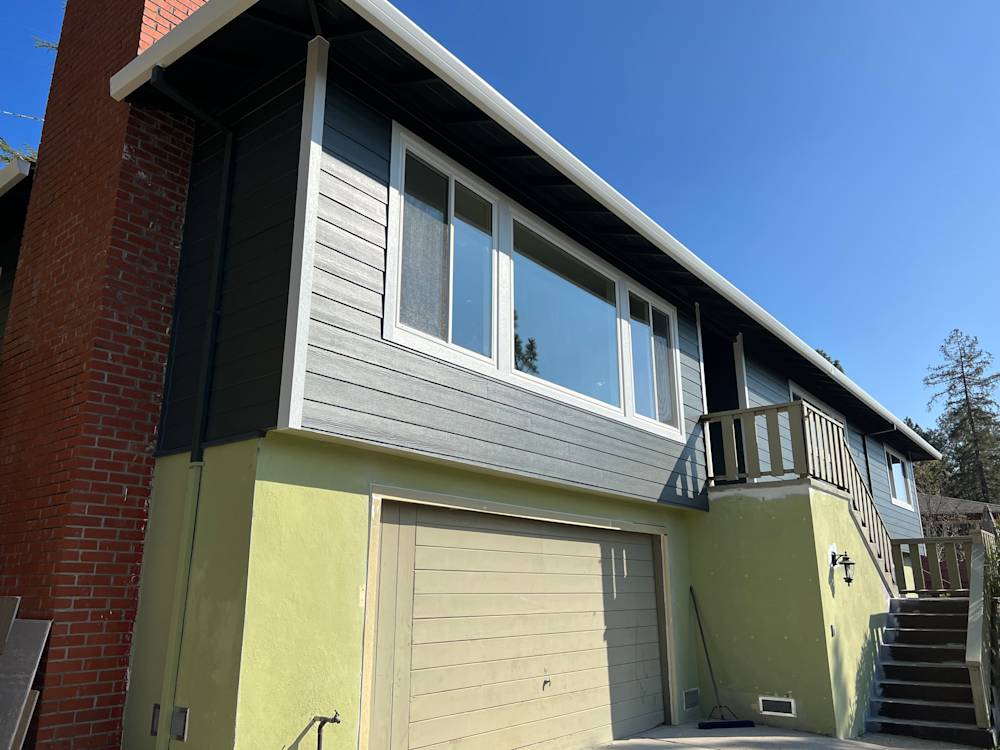 Exterior view of a two-story home in Sacramento with gray siding and green lower walls