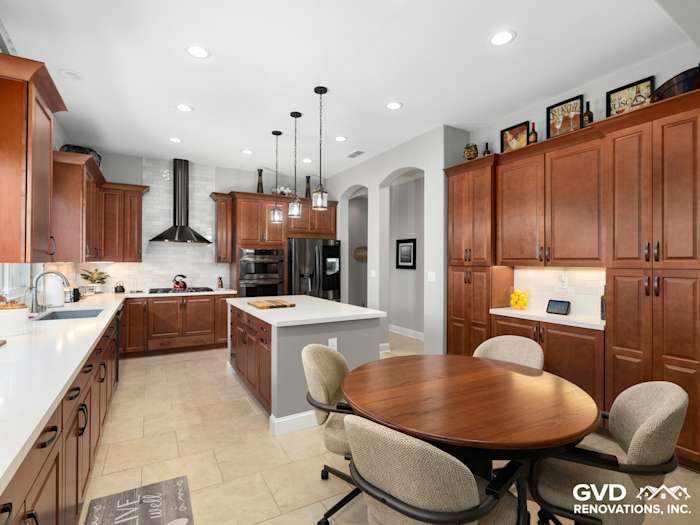 Modern kitchen remodel featuring dark wood cabinetry, stainless steel appliances, and an inviting round dining table